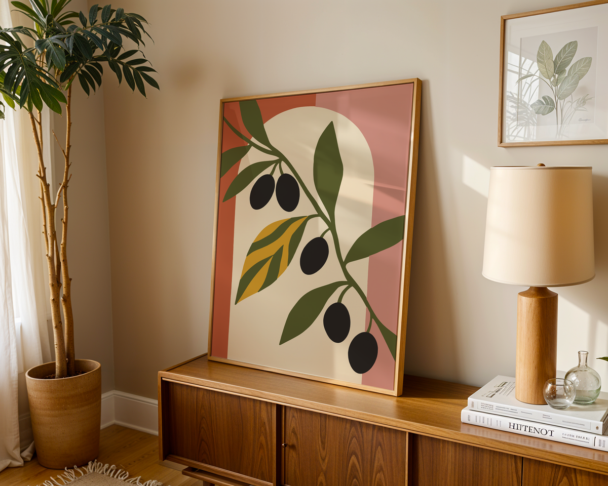 Olive leaf print with black olives leaning on a wooden sideboard in a warm living room