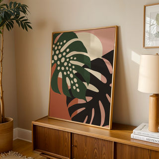 Tropical leaf print of two monstera leaves leaning on a wooden sideboard in a warm living room