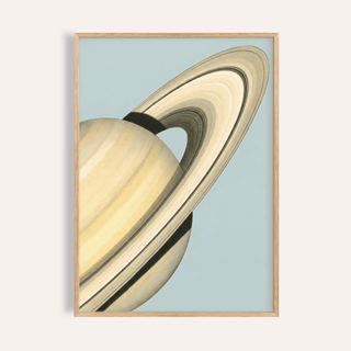 Framed Saturn wall art close-up showing the planet with rings on a pale blue background