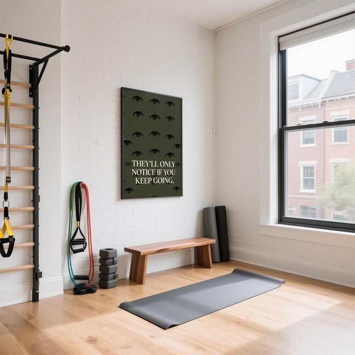 Gym Artwork print with eyes and motivational quote in green and black on a white brick wall in a bright workout space