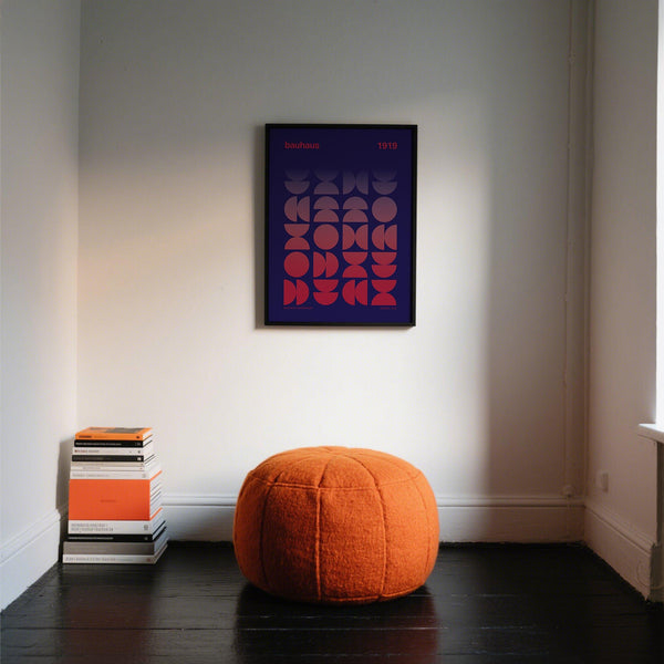 Graphic design poster hanging in a mid-century modern living space.