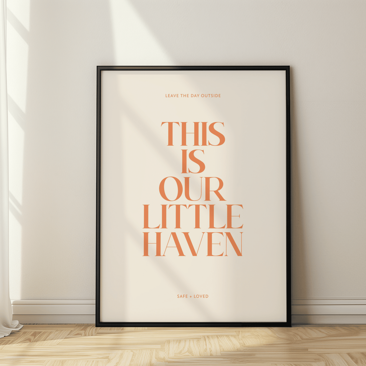 Framed poster with 'This is our little haven' text on a wall.