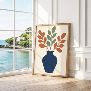 Navy vase of rust and sage stems leaning by a bright window with a sea view