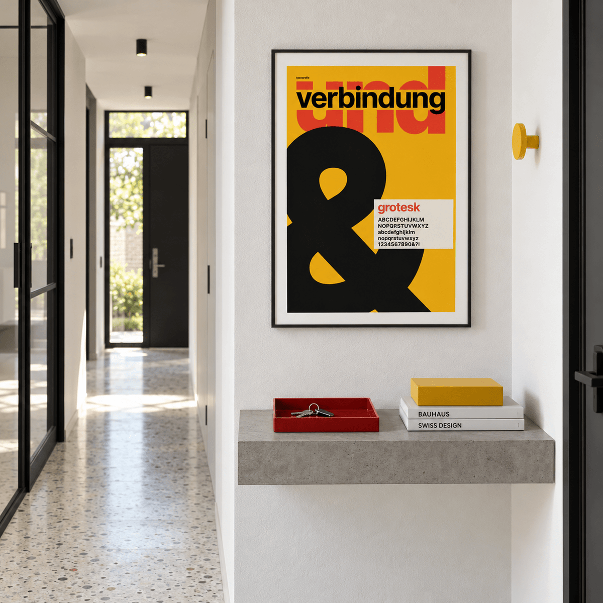Ampersand on mustard yellow print above a console table in a hallway