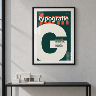 Cream letter G on forest green print above a console table in a hallway