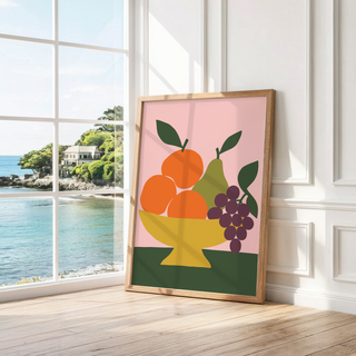 Mustard bowl of fruit on pink leaning by a bright window with a sea view
