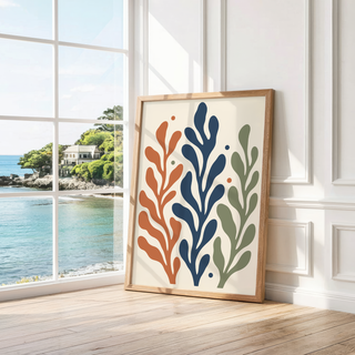 Rust, navy and sage frond print leaning by a bright window with a sea view