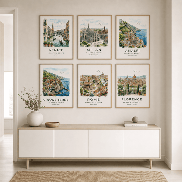 Framed artworks of famous cities on a wall above a white console table.