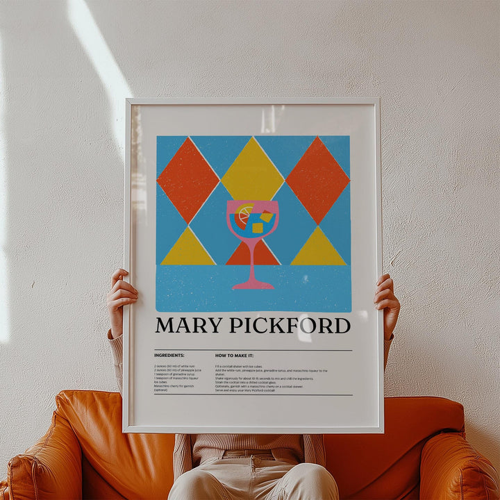 Framed print of Mary Pickford cocktail illustration with geometric shapes held above a brown sofa