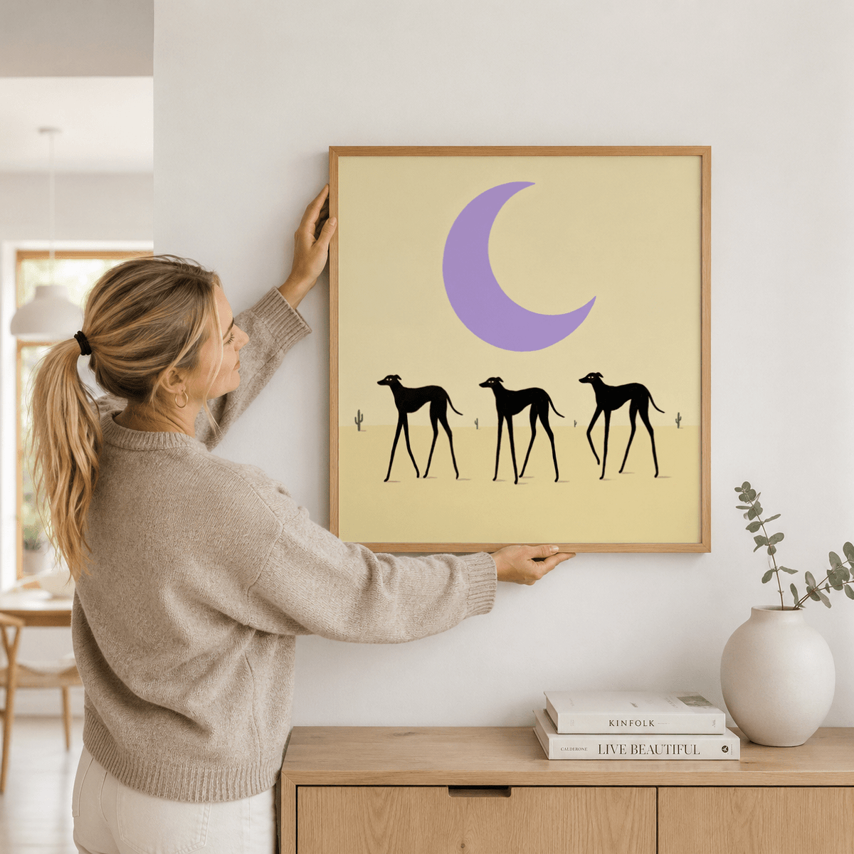 Silhouette illustration poster featuring three dogs beneath a large moon on an open sky background
