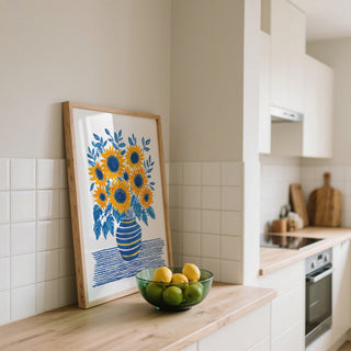 Sunflower Print wall art with golden blooms in a rustic blue vase on striped tablecloth.