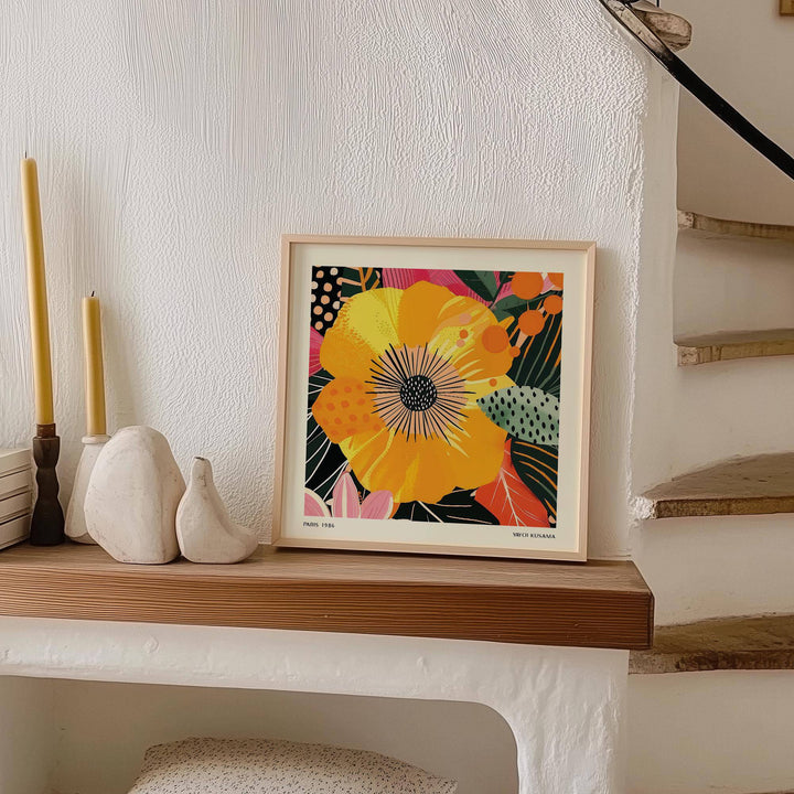 Yellow Flower Art print leaning on a wooden shelf next to candles and pottery in a neutral room