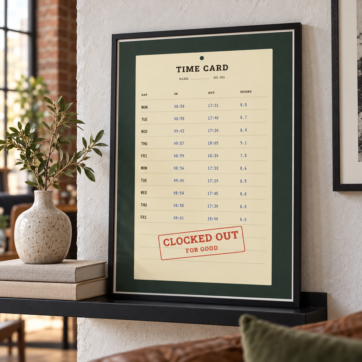 Clocked out time card print leaning on a shelf beside books and plants