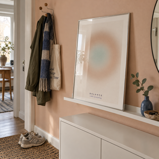 Sand and sage aura print on a ledge in a hallway against a peach wall