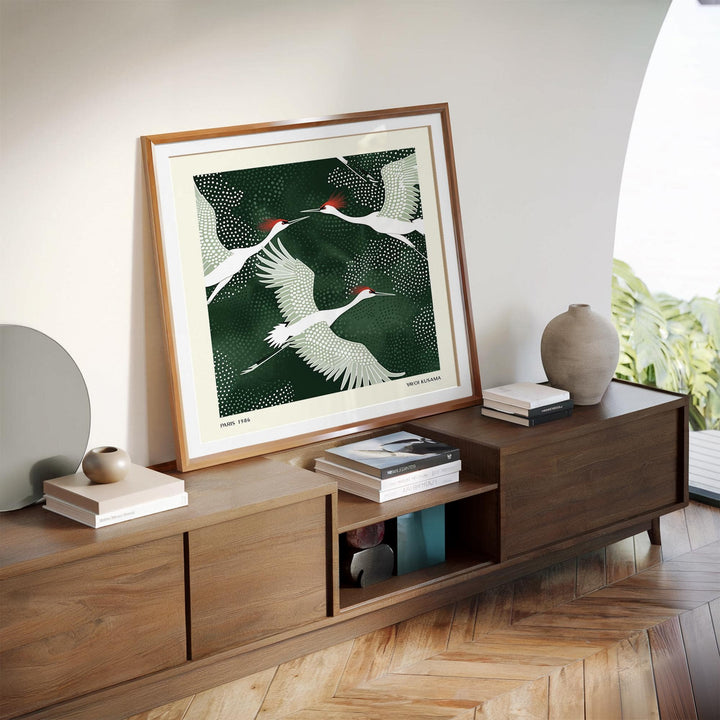 White Crane Birds Art print leaning on wooden sideboard with books and pottery