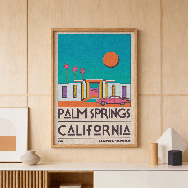 Palm Springs art print of a retro desert house with pink car and orange sun above a wooden sideboard with vases