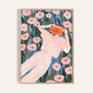 Reclining woman reading poster with open book among large flowers