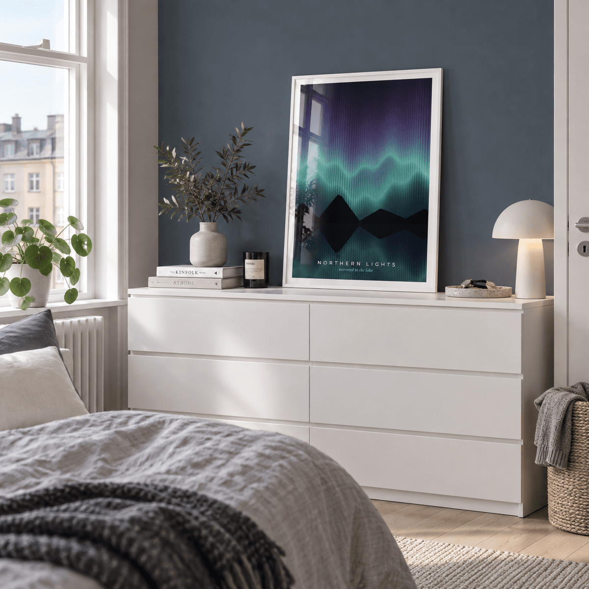 Northern lights lake reflection print on a dresser against a blue grey wall
