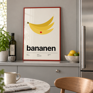 Yellow bananas with red sticker print on a shelf in a kitchen against a grey wall