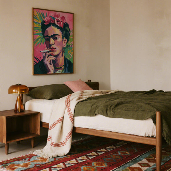 Frida Kahlo painting showing tropical leaves, bright pink backdrop, and confident expression.