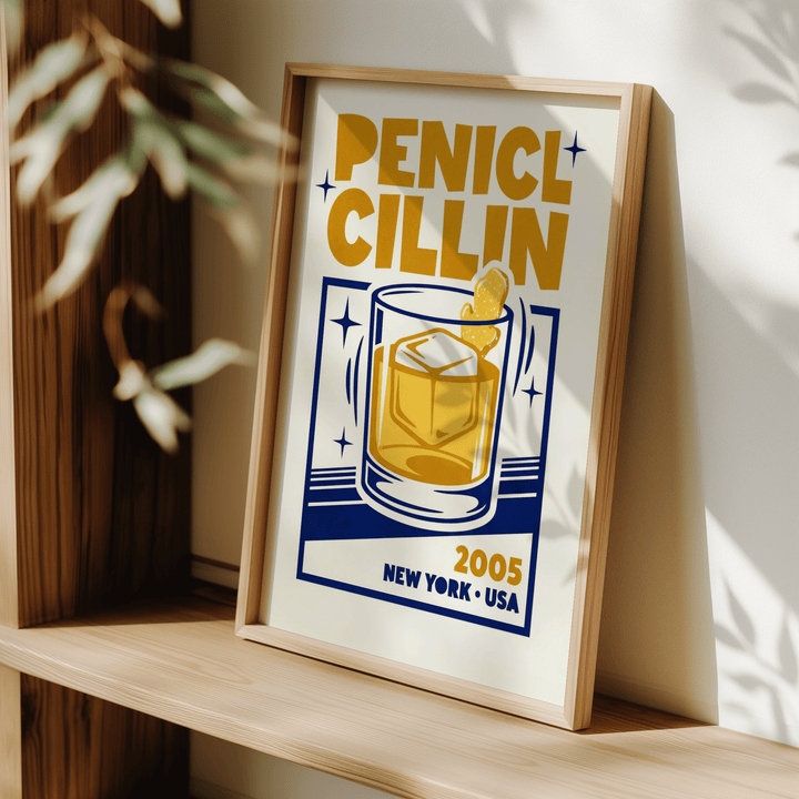 Bar decor wall art showing a mid-century style illustration of a penicillin cocktail in yellow and blue leaning on a wooden shelf