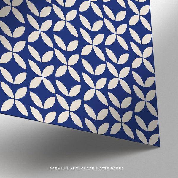 A poster of blue modern wall art laid flat next to a kraft paper tube for scale.