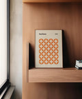 Modern interior with framed orange minimalist print hanging above console table.