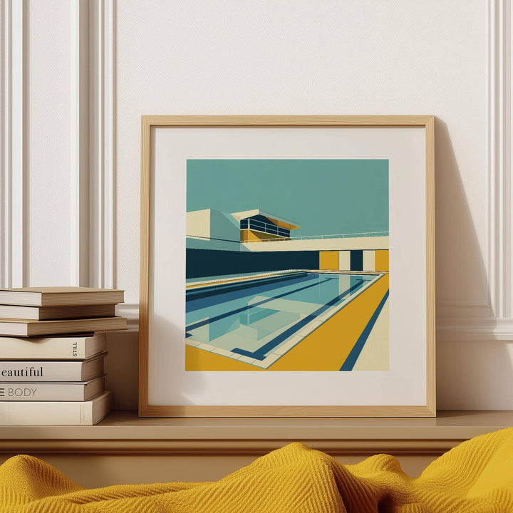 Minimalistic Art framed print of a poolside scene in yellow, teal and blue leaning on a shelf with books