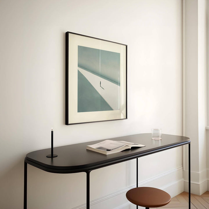 Art Prints Square framed print of a solitary person in shadow with beige and blue tones above a black console table