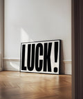 Minimalist luck poster displayed vertically in a modern room.