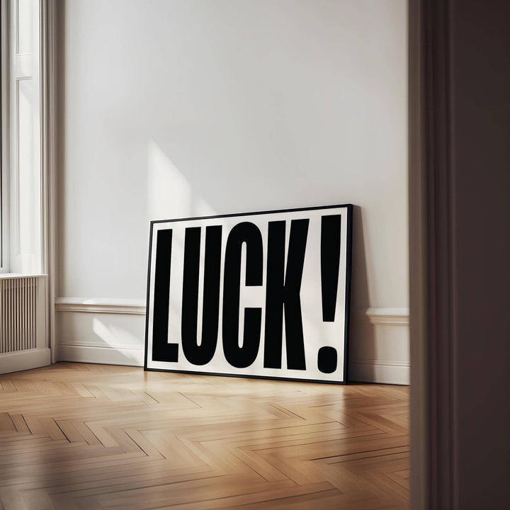 Good Luck Print leaning on a wooden floor against a white wall with sunlight streaming in