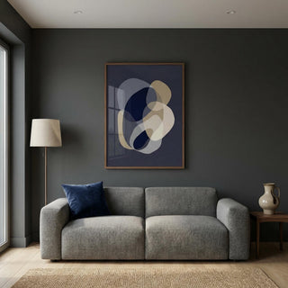 Modern living room with a gray sofa, abstract art on the wall, and a lamp.