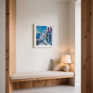 Wooden bench with cushion against a wall with a framed Santorini Wall Art painting