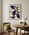 Dining room with a framed artwork of aubergines on the wall above a wooden table.