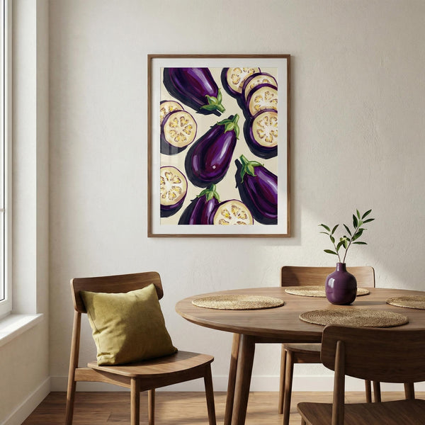 Dining room with a framed artwork of aubergines on the wall above a wooden table.