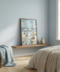 Nautical-themed artwork on a wooden shelf in a bedroom with light blue walls and a bed.