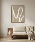 Beige sofa with a wooden frame in a room with a abstract wall art