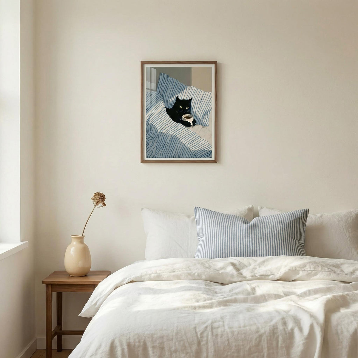 Bedroom with a bed, side table, and framed artwork on the wall.
