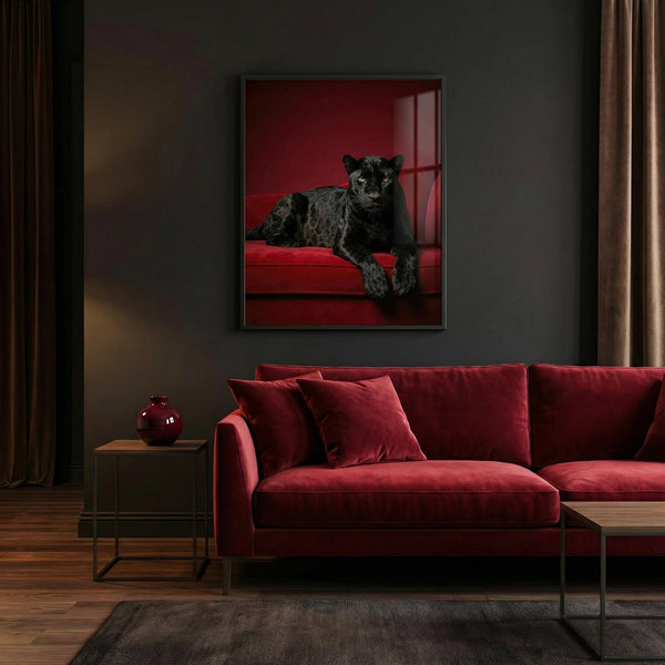 Red sofa in a living room with a print of a panther on the wall.