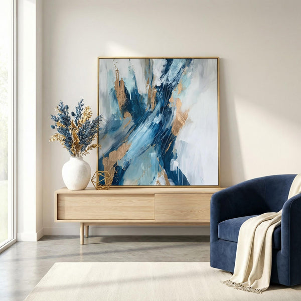 Modern living room with abstract art, vase, and blue armchair.