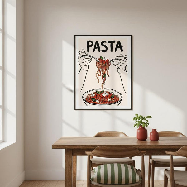 Framed artwork of hands holding pasta with a bowl of pasta below, on a wall above a dining table.