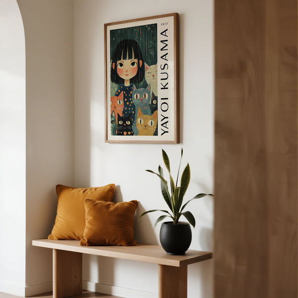 Framed artwork of a girl with a cat on a wall above a wooden bench with cushions and a plant.
