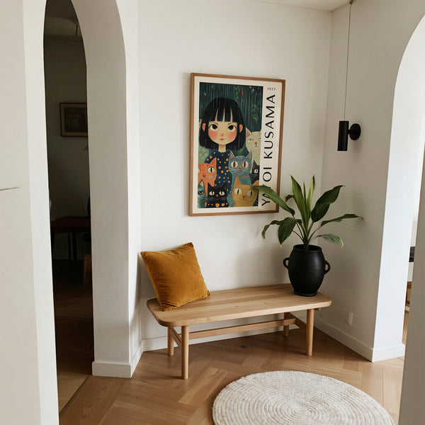 Narrow hallway with a wooden bench, yellow cushion, black vase with plant, and framed Kusama artwork on the wall.