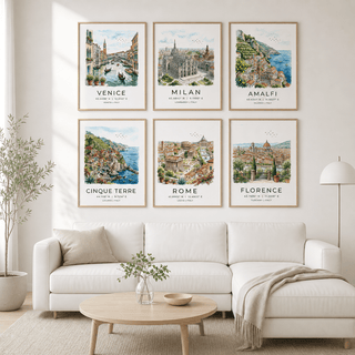 Living room with framed prints of famous Italian cities on a wall above a white sofa.