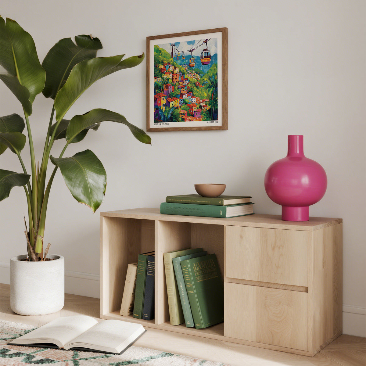 Wooden shelf with books and a pink vase, plant, and colorful artwork in the background.