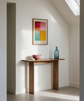 Modern interior with a wooden console table, color block art, and decorative bottle.