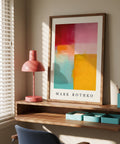Color block art print by Mark Rothko on a wooden shelf with a pink lamp and blue chair.