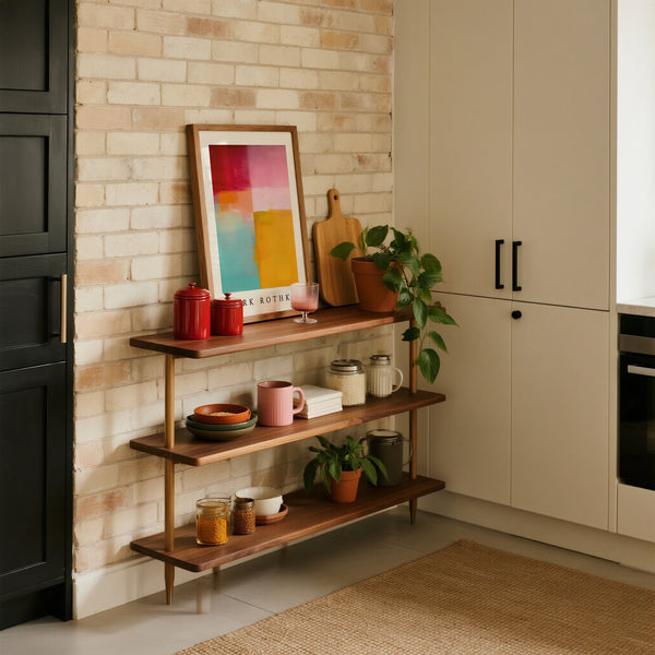 Wooden shelf with decorative items against a brick wall in a kitchen.