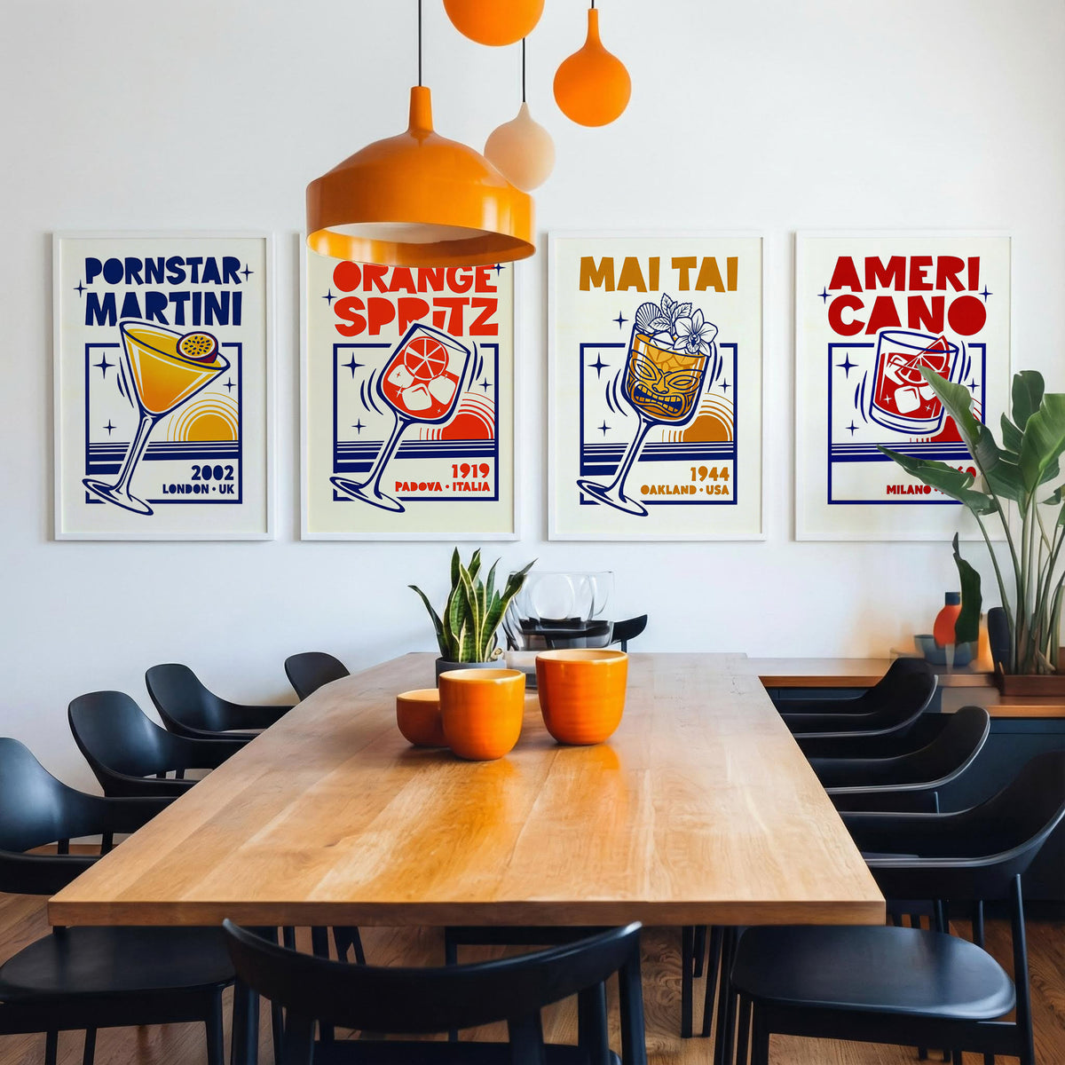 A dining room scene with a wooden table, black chairs, orange pendant lights, and four framed retro-style posters on the wall. The posters feature bold text including 'PORNSTAR MARTINI', 'ORANGE SPRITZ', 'MAI TAI', and 'AMERI CANO' with illustrated drink glasses and starburst graphics.