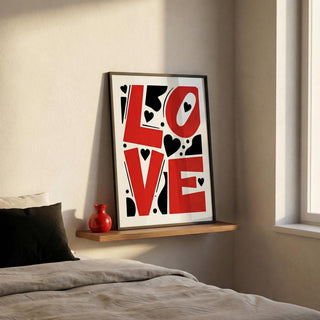 Framed 'LOVE' artwork on a wall above a bed